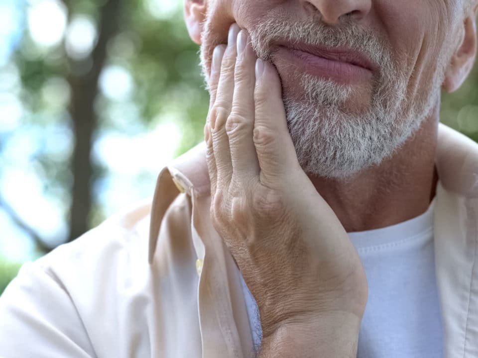 Older man with white beard with gum disease at Washington MI dentist